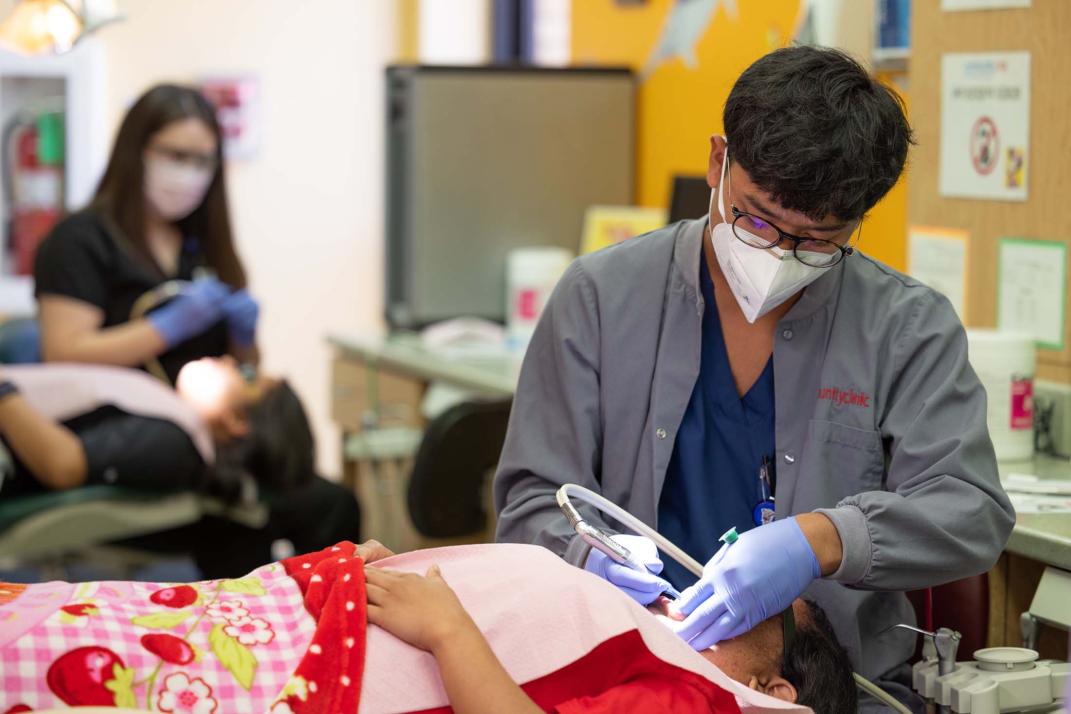 Community Clinic dental hygienist cleaning a patient's teeth